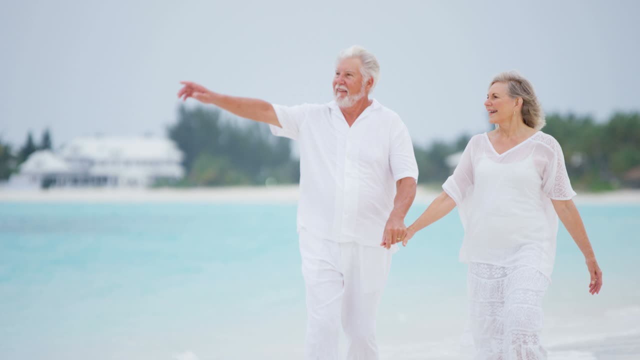 зрелая кавказская пара гуляет вместе на тропическом пляже