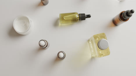 close up of cream tub and glass bottles with copy space on white background