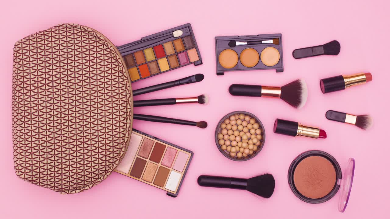 Make up products move  next to makeup kit on pink theme. Stop motion