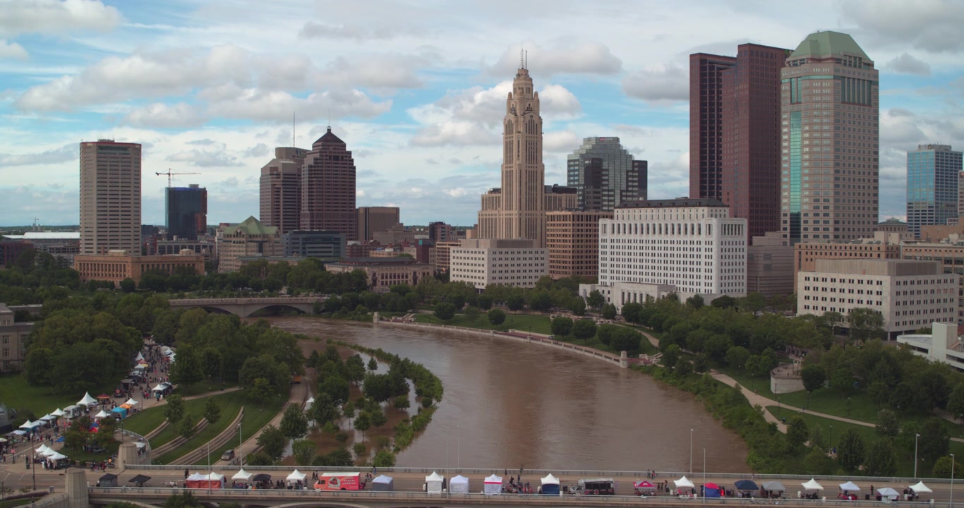 Denna etablerande flygdrönarbild fångar Columbus, Ohios stadssilhuett längs Scioto River när den slingrar sig genom staden.