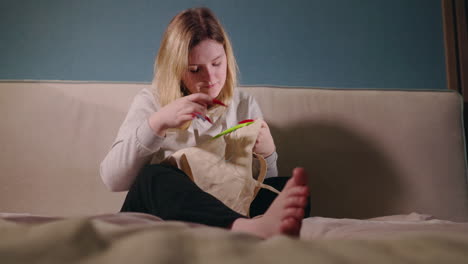 woman knitting/sewing a canvas bag at home