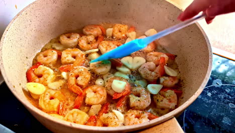 close-up of shrimps sizzling in a pan with colorful vegetables, cooked fresh at home.
