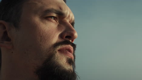 Portrait-bearded-man-looking-forward-on-nature.-Close-up-serious-sportsman-face.