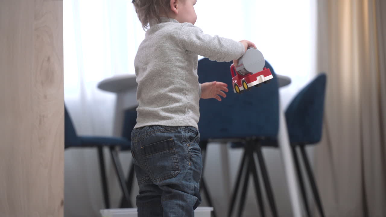 Side View Of A Baby Picking Up A Toy From The Top Of The Dresser