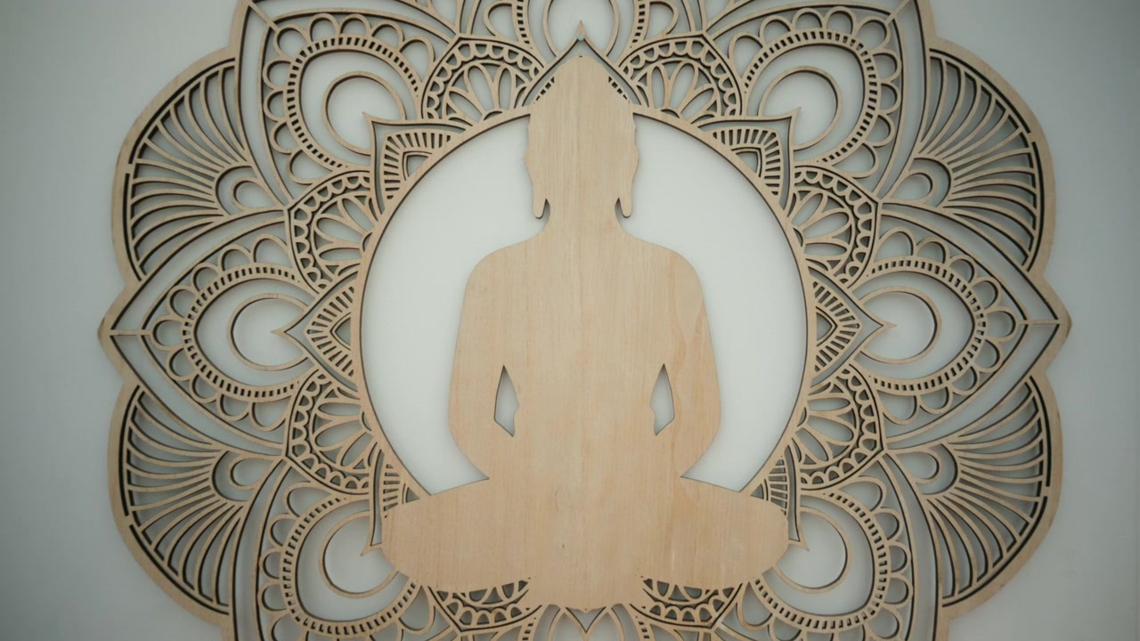 Silhouette di Buddha in legno in meditazione, incorniciata da un intricato motivo mandala, che simboleggia pace, spiritualità e consapevolezza.