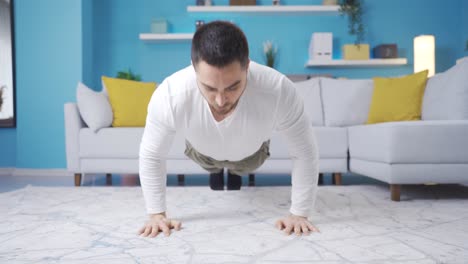 un joven atleta haciendo flexiones en la sala de estar de su casa.