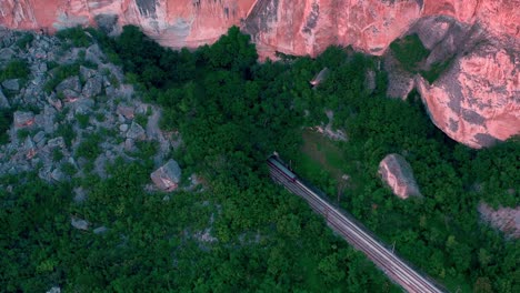 Aerial-view-of-train-entering-a-tunnel-through-the-rocks