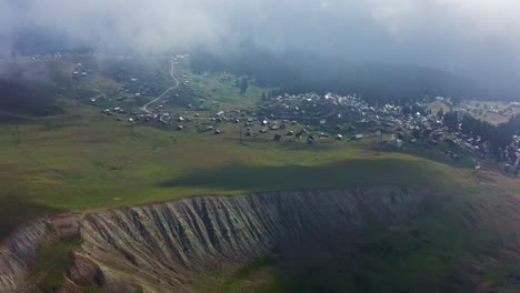 toma aérea de drones: montañas verdes y pueblo de verano en la meseta