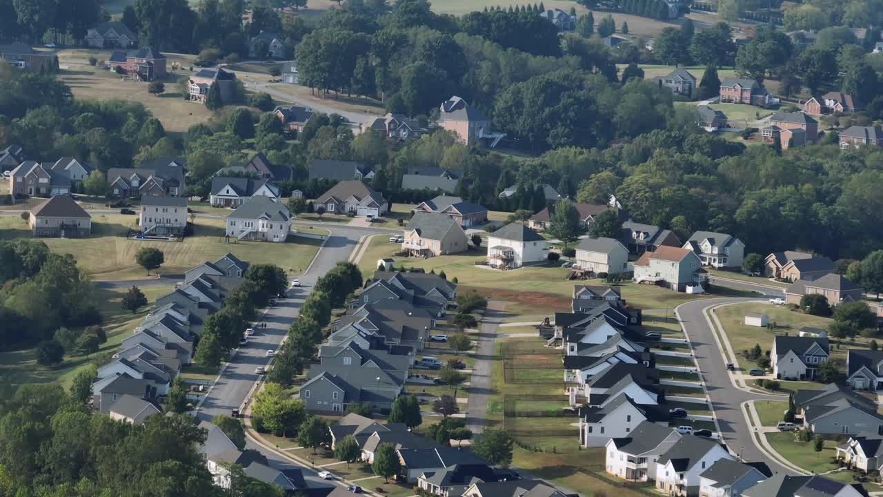 Luftfoto af amerikansk forstadskvarter med parcelhuse, træomkransede gader og grønne omgivelser. Solrig sommerdag i et roligt boligområde i Virginia