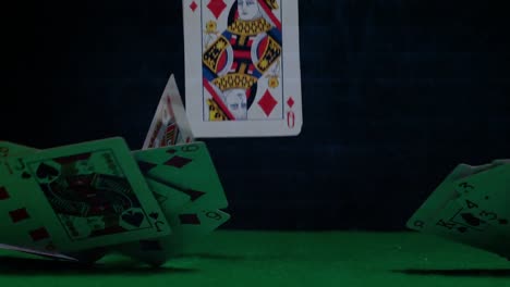 game cards falling down on green table