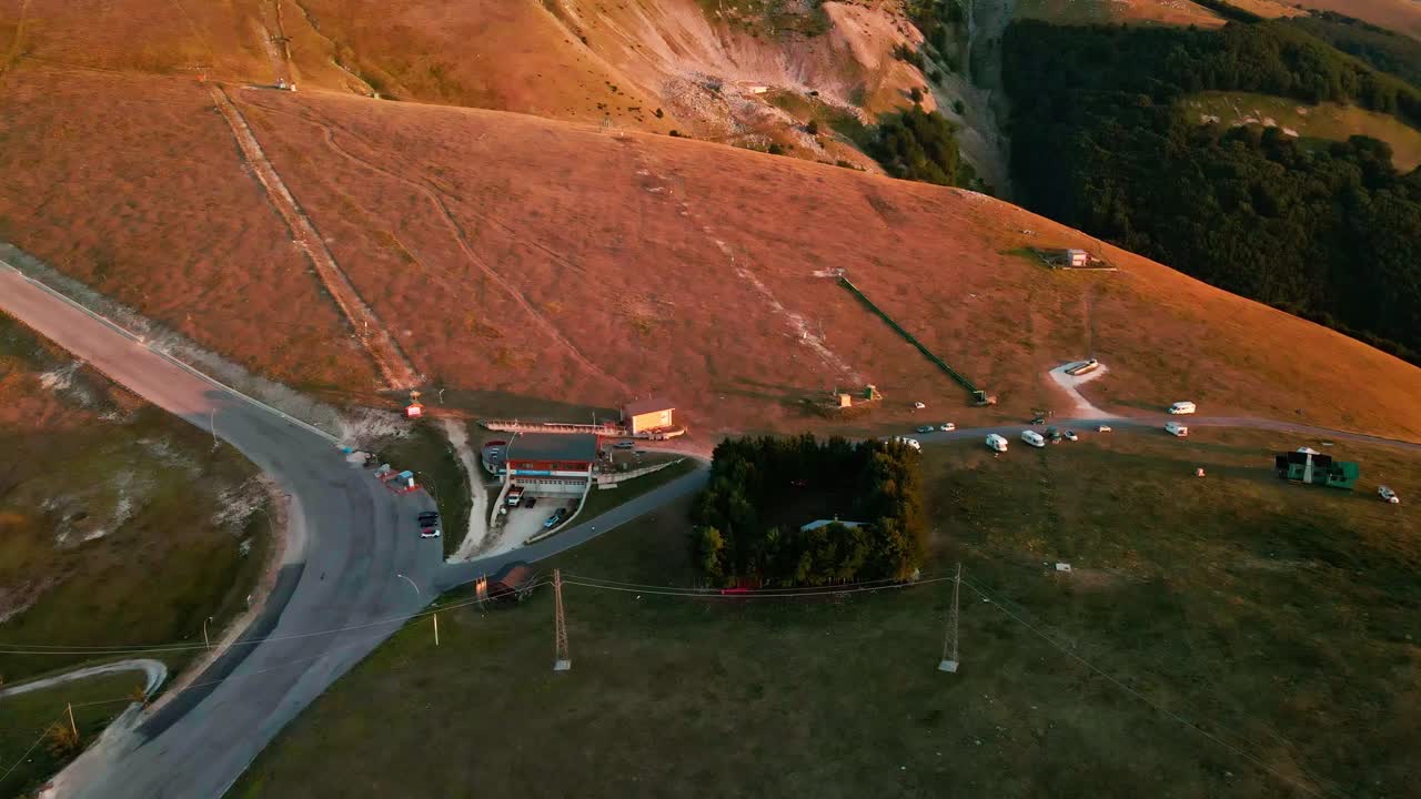 Aerial View On Vans And Campers Parked Near The Ski Lifts In The Majella Mountains During Sunset In Abruzzo, Italy - drone shot