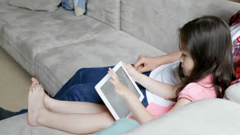 padre con su hija usando tableta digital 4k