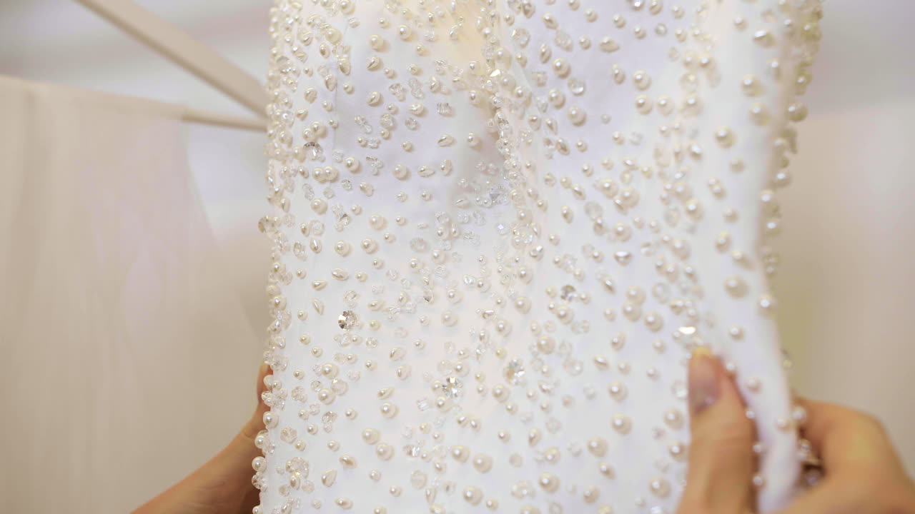 인식 할 수 없는 여성이 웨딩 드레스를 선택하고 있습니다.