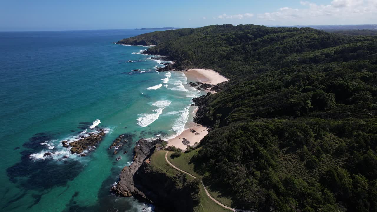 Scopri Broken Head Beach, Byron Bay, Headland e la lussureggiante riserva naturale, NSW, Australia: ripresa aerea con drone