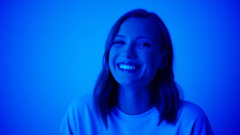 smiling woman illuminated by blue light