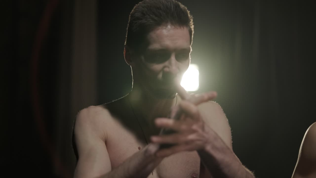 프로 댄서 그룹이 어 속에서 카포에이라를 연습하고 있으며, 스튜디오의 검은 바탕에 스포트라이트가 있습니다. 댄스의 요소를 결합하는 아프리카-브라질 무술입니다.