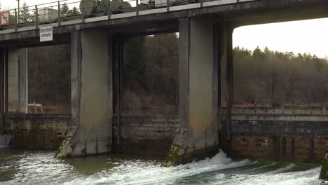 an old, traditional wooden weir zoomed out to reveil the flowing water under a bright sky at day