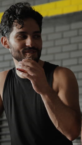 man enjoying a sports nutrition bar in the gym