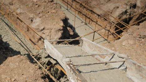 concrete flows through the pipe into the foundation of the basement construction of cottages concept