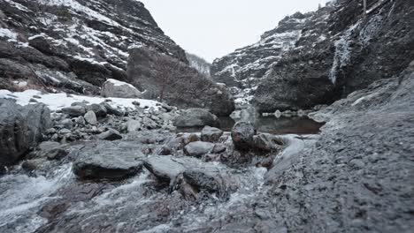 Eisiger-Bach-Fließt-Durch-Eine-Verschneite-Bergschlucht,-Bedeckter-Himmel