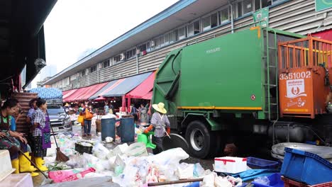 workers loading trash into a garbage truck