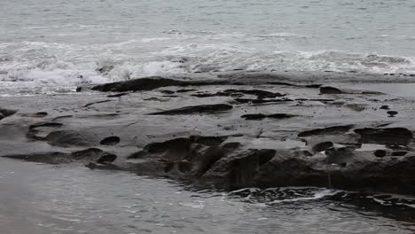 Olas-Del-Mar-Rompiendo-Brutalmente-Sobre-Rocas-Junto-Al-Mar