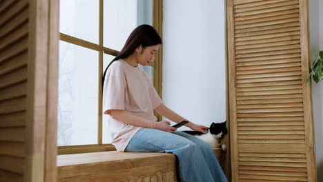 woman with cat by the window