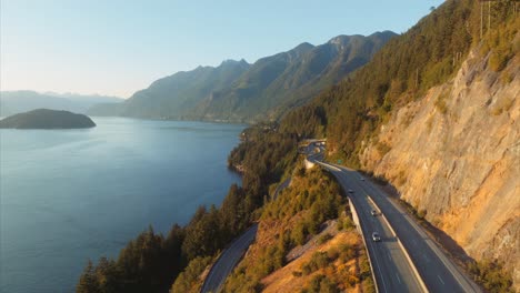 golden light on side of mountain and aerial view of trans canada highway