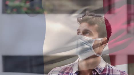 Animation-of-flag-of-france-waving-over-caucasian-man-wearing-face-mask-in-city-street