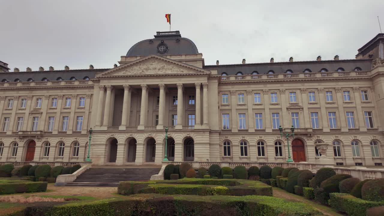 Front view of Royal Palace of Brussels with Belgian flag on cloudy day