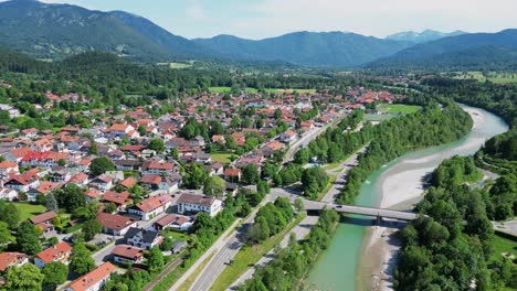 Luftaufnahme-Einer-Vorstadtstadt,-Eingebettet-In-Berge-Und-Umgeben-Von-Bäumen,-Entlang-Eines-Flusses-Und-Waldes,-Die-Durch-Eine-Brücke-Verbunden-Sind