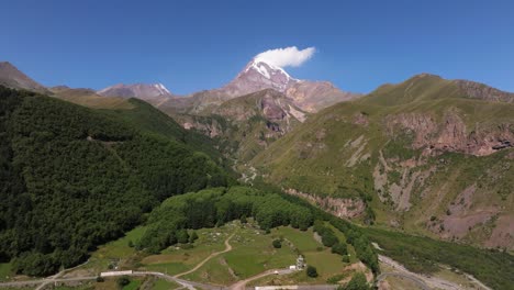 drone flying away from kazbek mountain in gergeti, georgia