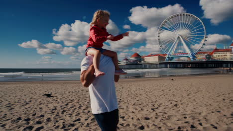 father and child enjoying a shoulder ride on the beach