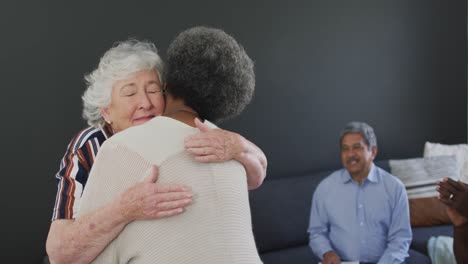 mujer mayor caucásica dando apoyo a una amiga afroamericana en una reunión