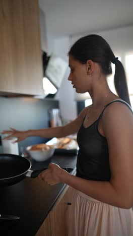 una adolescente cocinando en la cocina