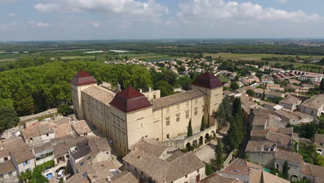 drone volando hacia el castillo de castries en el sur de francia. parque aéreo y árboles