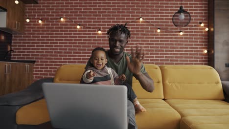 african american father and preschooler child speak on conversation video chat from home