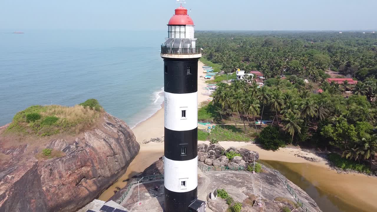 Il faro di Fire Island, in bianco e nero, si erge alto dietro la stazione dal tetto rosso e il tortuoso lungomare che conduce attraverso le dune alla spiaggia sabbiosa e alla costa atlantica, vista aerea da drone, New York, Stati Uniti