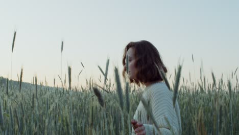 woman in a wheat field at sunrise/sunset