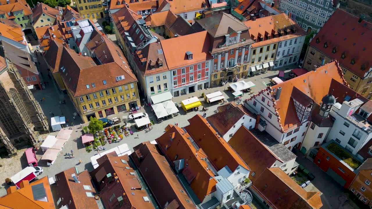 4K Aerial Drone Video of Farmers Market in the Courtyard between the St. Johannis Kirche Church and Kirche St. Gumbertus Church in Ansbach, Germany