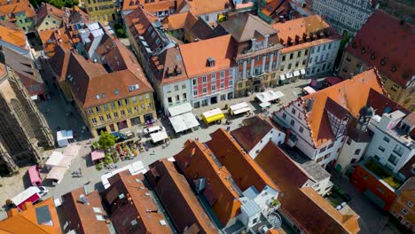 4k aerial drone video of farmers market in the courtyard between the st. johannis kirche church and kirche st. gumbertus church in ansbach, germany