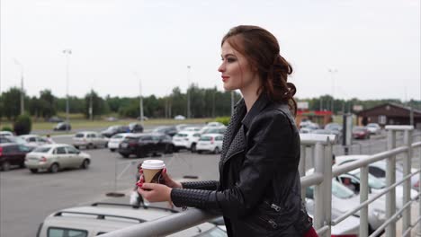 woman with coffee in a parking lot