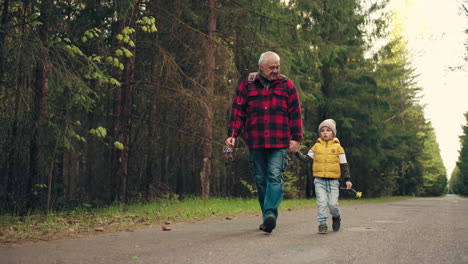 vecchio e suo nipote stanno camminando e parlando nonno con la canna da pesca in mano