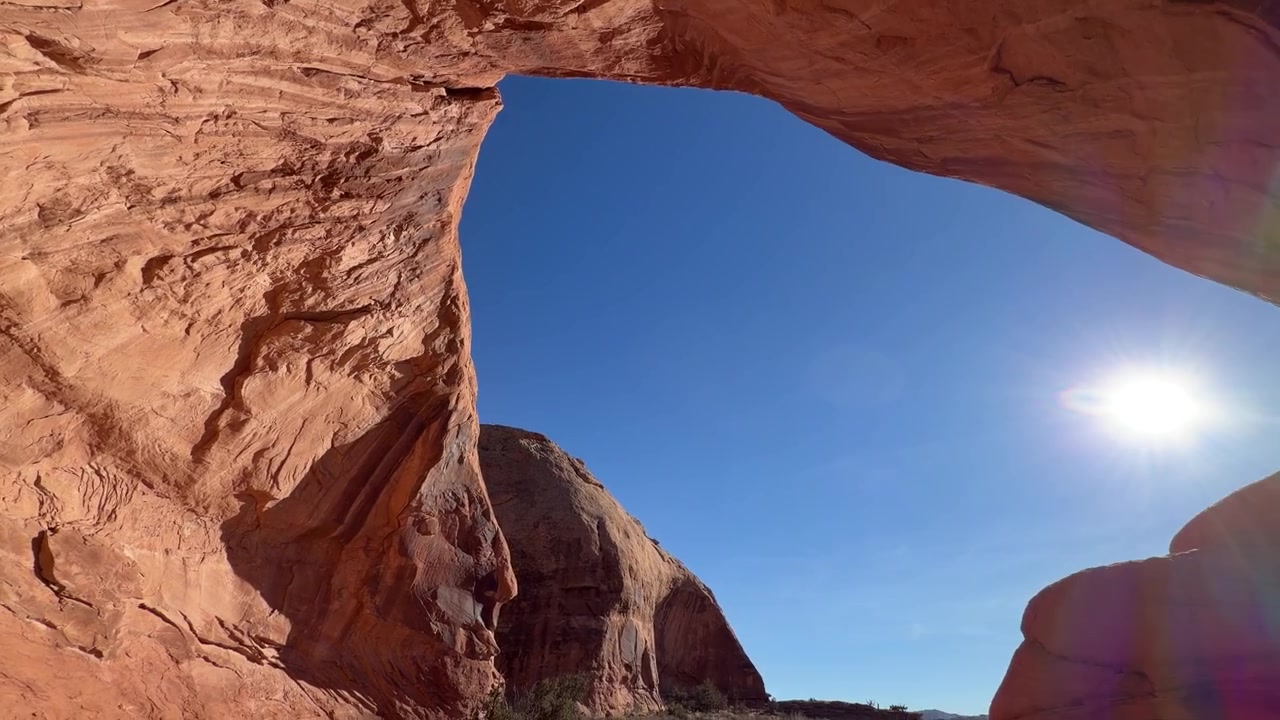 Ampia veduta dal basso di un arco panoramico nel paesaggio dello Utah, USA, sotto il sole in una giornata calda