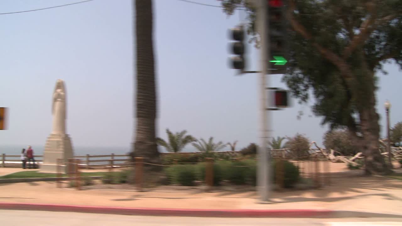 un automóvil viaja a lo largo de una calle costera en santa monica california como se ve a través de la ventana lateral