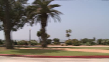 a car travels along a seaside street in santa monica california as seen through the side window