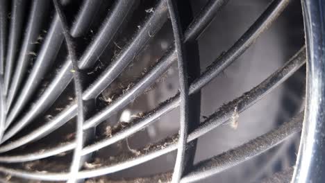 Dirty-and-worn-old-desk-fan-blowing-cool-wind-with-dirt-and-grime-accumulating-on-the-fan-grill-in-front-of-blades