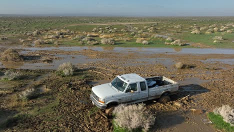 Off-roading-in-the-Mojave-Desert,-trucks-stuck-in-the-mud-in-the-aftermath-of-an-unexpected-downpour---aerial-view