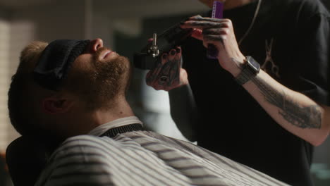 barber shaving a client's beard