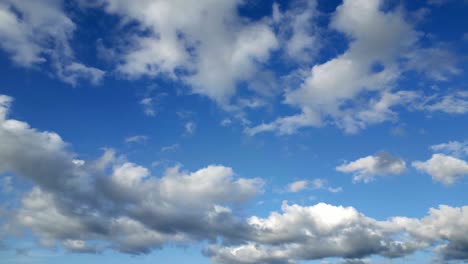 right to left shot no landscape grey white clouds over blue sky no sun